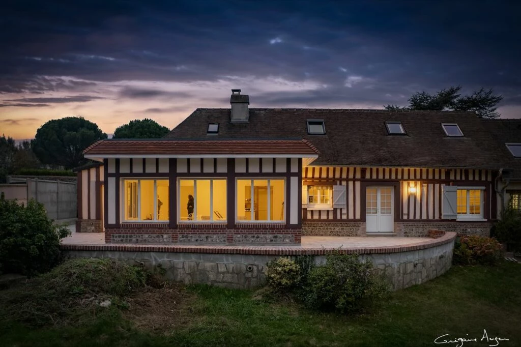 Maison normande étendue et rénovée, vue d'ensemble au crépuscule